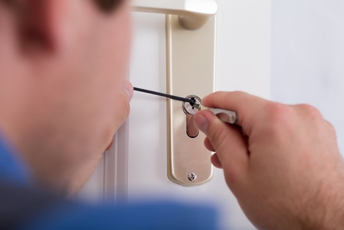 Locksmith picking a lock on a upvc door